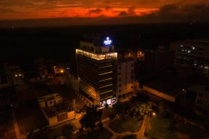 wysoki budynek z niebieskim znakiem na górze w nocy w obiekcie Awqa Concept Hotel w mieście Trujillo