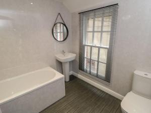 a bathroom with a sink and a tub and a toilet at Ashben Cottage in Whitby +12 photos