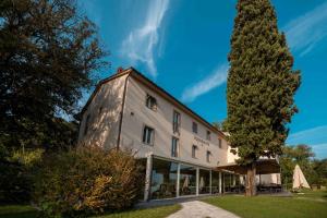 ein großes weißes Gebäude mit einem Baum daneben. in der Unterkunft Villa Giorgia Albergo in Collina in Pistoia