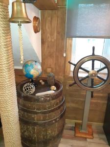 een kamer met een stuurwiel en een vat met een bol bij Yacht Club in Liepāja