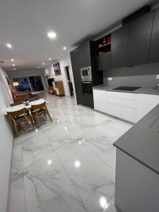 a kitchen with white marble floors and black cabinets at New villa with rooftop terrace and pool in Daya Nueva