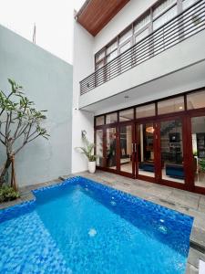 a swimming pool in front of a house at Cottonwood 4BR Villa Sutami with Pool Netflix BBQ in Bandung
