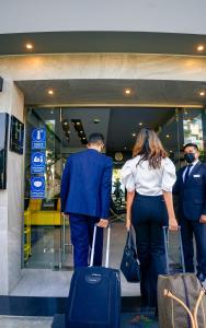 a man and a woman walking through an airport with luggage at Awqa Concept Hotel in Trujillo