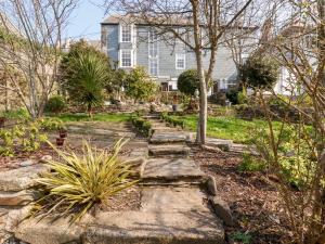 a garden with stone steps in front of a house at Cherry Orchard House in St Austell