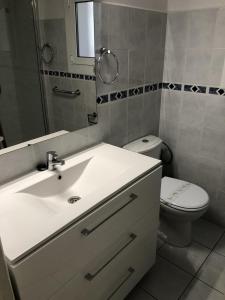 een badkamer met een wastafel, een toilet en een spiegel bij apartamento a pie de playa ref 220 in Roses