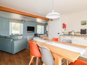 a kitchen and living room with a table and chairs at Cherry Orchard House in St Austell