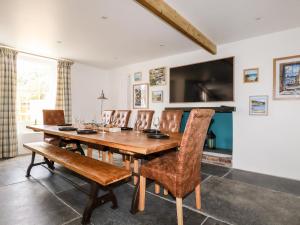 a dining room with a wooden table and chairs at Cherry Orchard House in St Austell