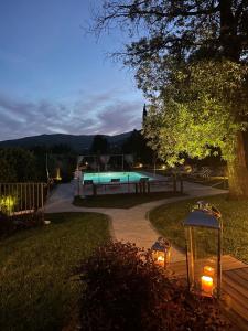 a backyard with a swimming pool at night at Villa Giorgia Albergo in Collina in Pistoia