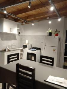 a kitchen with a table and a white refrigerator at Departamento familiar in General Roca