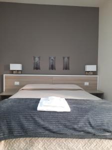 Un dormitorio con una cama con una toalla blanca. en COSTA APARTMENT NAPLES en Nápoles