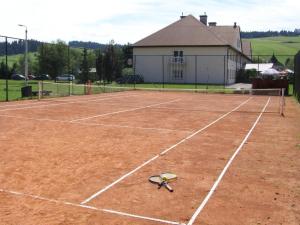 a tennis racket sitting on a tennis court at Hotel**Pieniny in Niedzica