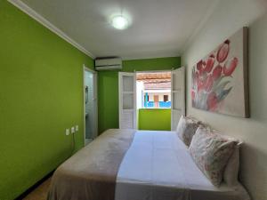 1 dormitorio con paredes verdes y 1 cama. en Pousada Michele en Morro de São Paulo
