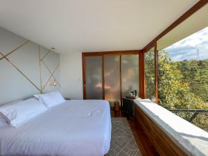 a bedroom with a bed and a large window at Nazca Glamping in Villamaría