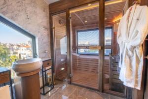 a bathroom with a shower and a toilet and a window at Espina Hotel in Antalya