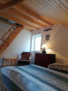 a bedroom with a bed and a chair and a window at Gościniec Śliwkowy Sad in Międzylesie