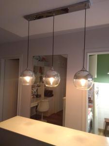 a kitchen with three lights hanging over a counter at Lindo monoambiente in Buenos Aires