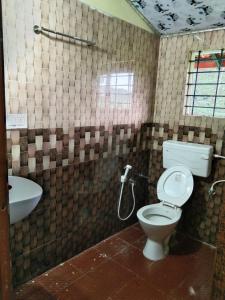 a bathroom with a toilet and a sink at SAMZ ESTATE Stay 3BHK in Madikeri +13 photos