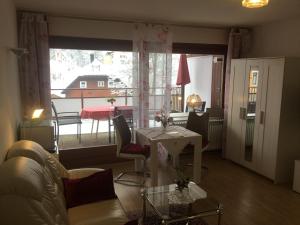 uma sala de estar com um sofá, uma mesa e uma janela em 1Z.FeWo 236 barbo Schwimmbad,Sauna,Fitness em Schönwald