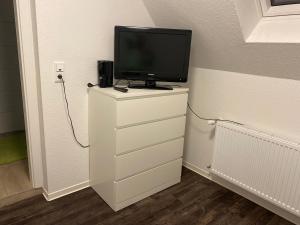 een tv op een dressoir met een televisie erop bij Nickelodeon in Stuhr