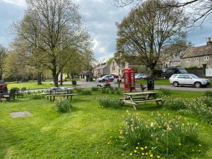 a park with picnic tables and a red phone booth at Primrose cottage in Tideswell