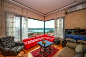 a living room with a red couch and a large window at O'Pera Okanlı Suites in Istanbul