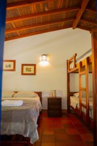 a bedroom with two beds and a bunk bed at FINCA HOTEL CARMONIA DEL BOSQUE in Venecia