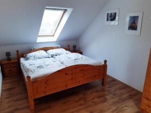 a bedroom with a wooden bed with a window at Ferienwohnung Günther am Park in Ditfurt