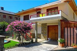 艾因薩的住宿－L'arome de Ainsa，带阳台的房子和一棵带粉红色花卉的树
