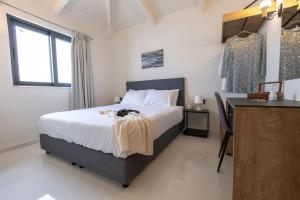 sypialnia z łóżkiem i biurkiem oraz łóżko o wymiarach 6 x 6 x 6 w obiekcie Astron Aparthotel by Estia w mieście Analipsi