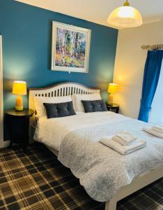 a bedroom with a bed with blue walls and two lamps at Zoe Bistro & Accommodation in Kilrush