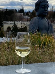 una copa de vino blanco sentada junto a una estatua en FerienwohnenAmSee Penthouse mit Whirlpool, en Überlingen