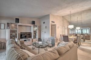 a living room with a couch and a table at Palm Beach Gardens Condo with Pool and Beach Access in Palm Beach Gardens