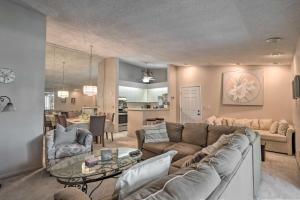 a living room with a couch and a table at Palm Beach Gardens Condo with Pool and Beach Access in Palm Beach Gardens