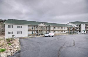 a large apartment building with two cars parked in a parking lot at Spacious Lakefront Condo with Community Pools! in Camdenton