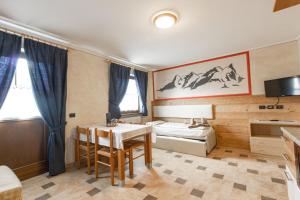 Zimmer mit einem Tisch und einem Bett sowie einem Schlafzimmer in der Unterkunft Chalet Li Baita Daniela in Livigno