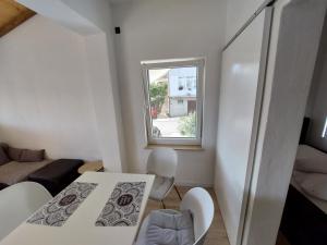 een kleine witte kamer met een tafel en een raam bij Mely Apartment in Krk