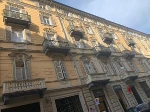 トリノにあるMaria Vittoria Houseの窓とバルコニー付きの大きな黄色の建物