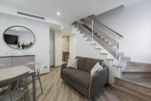 a living room with a couch and a staircase at B&B Piazza Roma in Norma