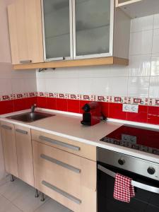 a kitchen with a sink and red and white tiles at Cotillo Lagoons Apartment in El Cotillo