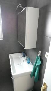 baño con lavabo blanco y armario en Apartment Larus en Vir