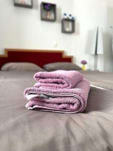 une pile de serviettes assises au-dessus d'un lit dans l'établissement Apartment Larus, à Vir