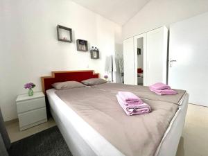 een slaapkamer met een bed met roze handdoeken bij Apartment Larus in Vir