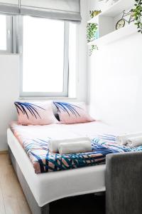 a bed with pillows on it in a room with a window at Lumen Studio in Wrocław