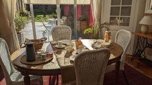 een eettafel met stoelen en een tafel en een glazen deur bij Rêve Bleu in Duinkerke