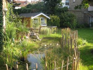 a garden with a pond in front of a house at Rêve Bleu in Dunkerque