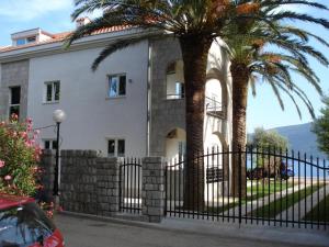 dom z palmami przed płotem w obiekcie Herceg Novi w mieście Herceg Novi