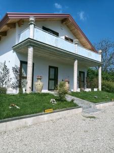 a white house with two large vases in the yard at B&B Desea in Poggiomarino