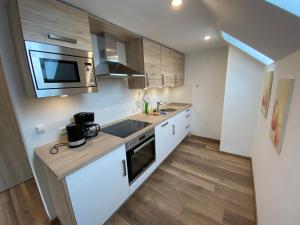 a kitchen with a sink and a microwave at Pension Pradler Wohnung Obergeschoß in Carolinensiel