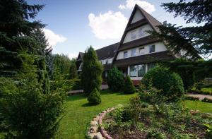 a house with a garden in front of it at Zajazd Trzy Dęby in Janów