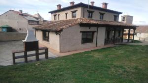 una casa grande con un instrumento grande en un patio en El Mirador del Hayedo, en Ríofrío de Riaza